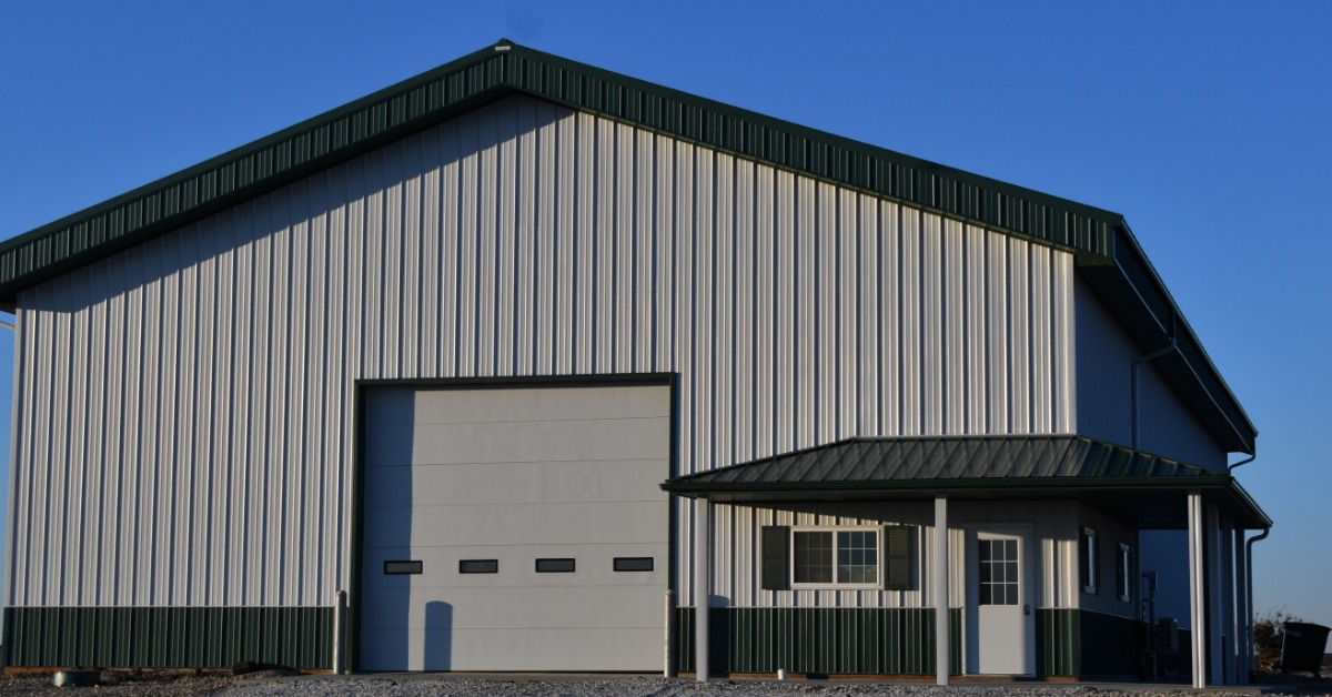 lesterbuildingsystems-470700-metal-agriculture-building-blogbanner.jpg A metal farm shop features a large overhead door and covered entrance with ample space for equipment access.